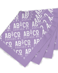 Four purple bandanas with the shortened Appalachian Botanical logo printed repeatedly staggered on top of each other